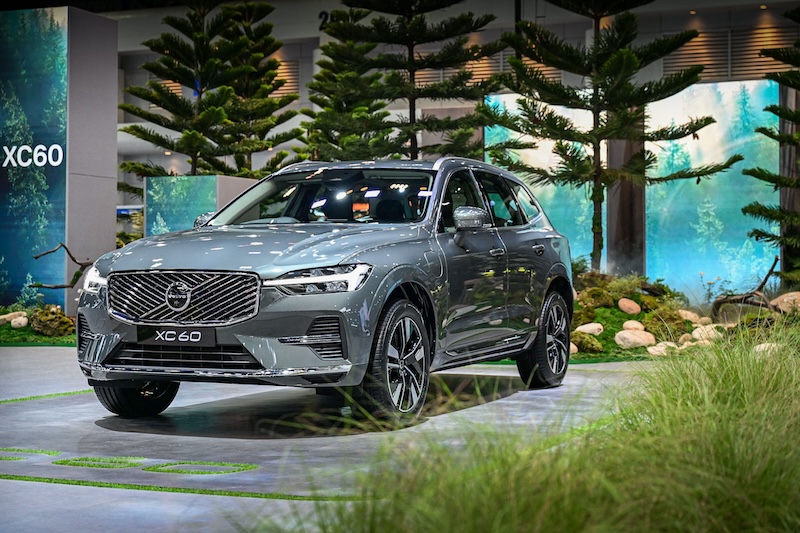 Volvo XC60 โฉมใหม่ บูธป่าสนสแกนดิเนเวีย – Motor Expo 2025 Volvo XC60 โฉมใหม่ในมุมมองเฉียงด้านหน้า ท่ามกลางบรรยากาศป่าสนที่บูธ Motor Expo 2025