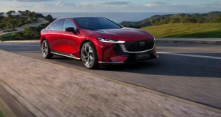 Mazda6e รถยนต์ไฟฟ้าสีแดงกำลังขับบนถนน สะท้อนดีไซน์หรูสปอร์ตที่คว้ารางวัล World Car Design of the Year 2026