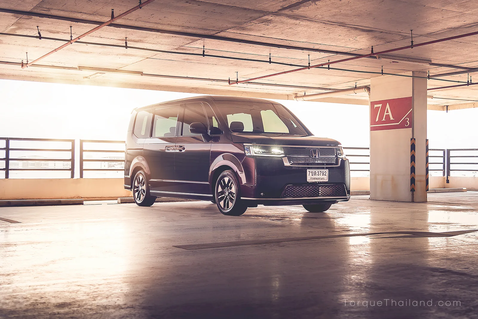 ภาพมุมกว้างด้านหน้าเฉียงของ Honda Step WGN e:HEV Spada ที่ออกแบบให้มีกระจกหน้าต่างขนาดใหญ่และเส้นสายตัวถังแนวตรงขนานกับพื้นเพื่อช่วยในการกะระยะขณะเข้าจอด