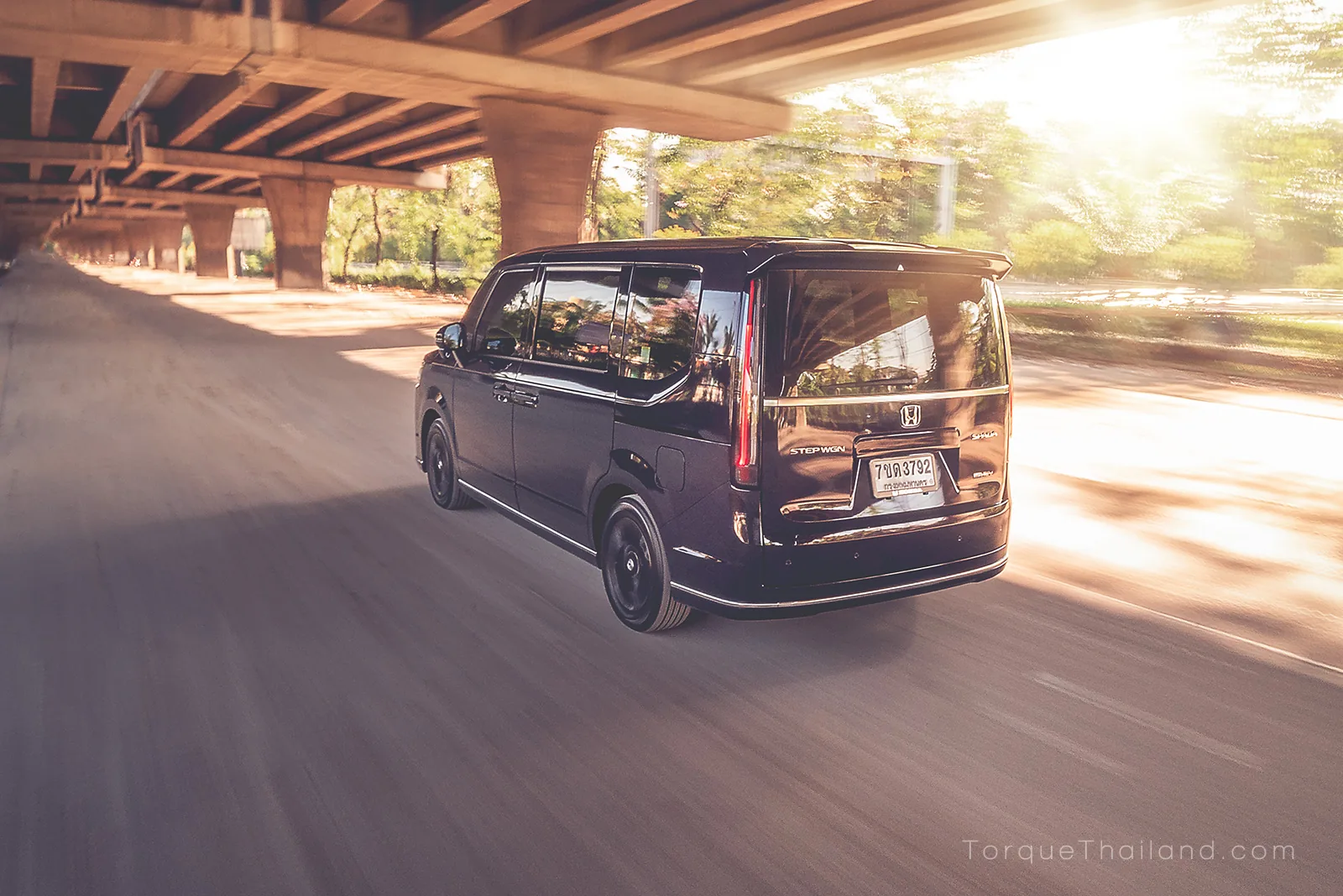 ภาพมุมท้ายเฉียงของ Honda Step WGN ขณะขับเคลื่อนซึ่งให้ความนุ่มนวลของช่วงล่างและมีพละกำลังเพียงพอในการบรรทุกผู้โดยสาร 7 คนพร้อมสัมภาระเดินทางไกล