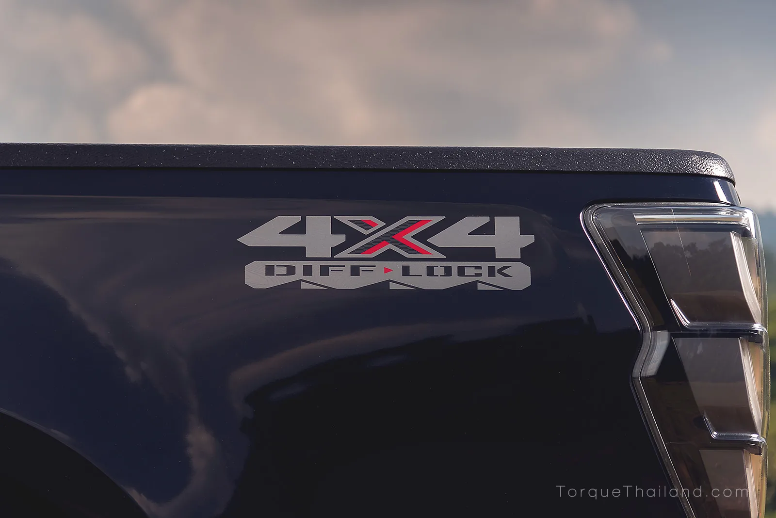 สติกเกอร์ 4x4 DIFF-LOCK ที่ด้านข้างท้ายกระบะ ระบุการติดตั้งระบบล็อกเฟืองท้ายที่สามารถทำงานร่วมกับระบบ Rough Terrain Mode ได้