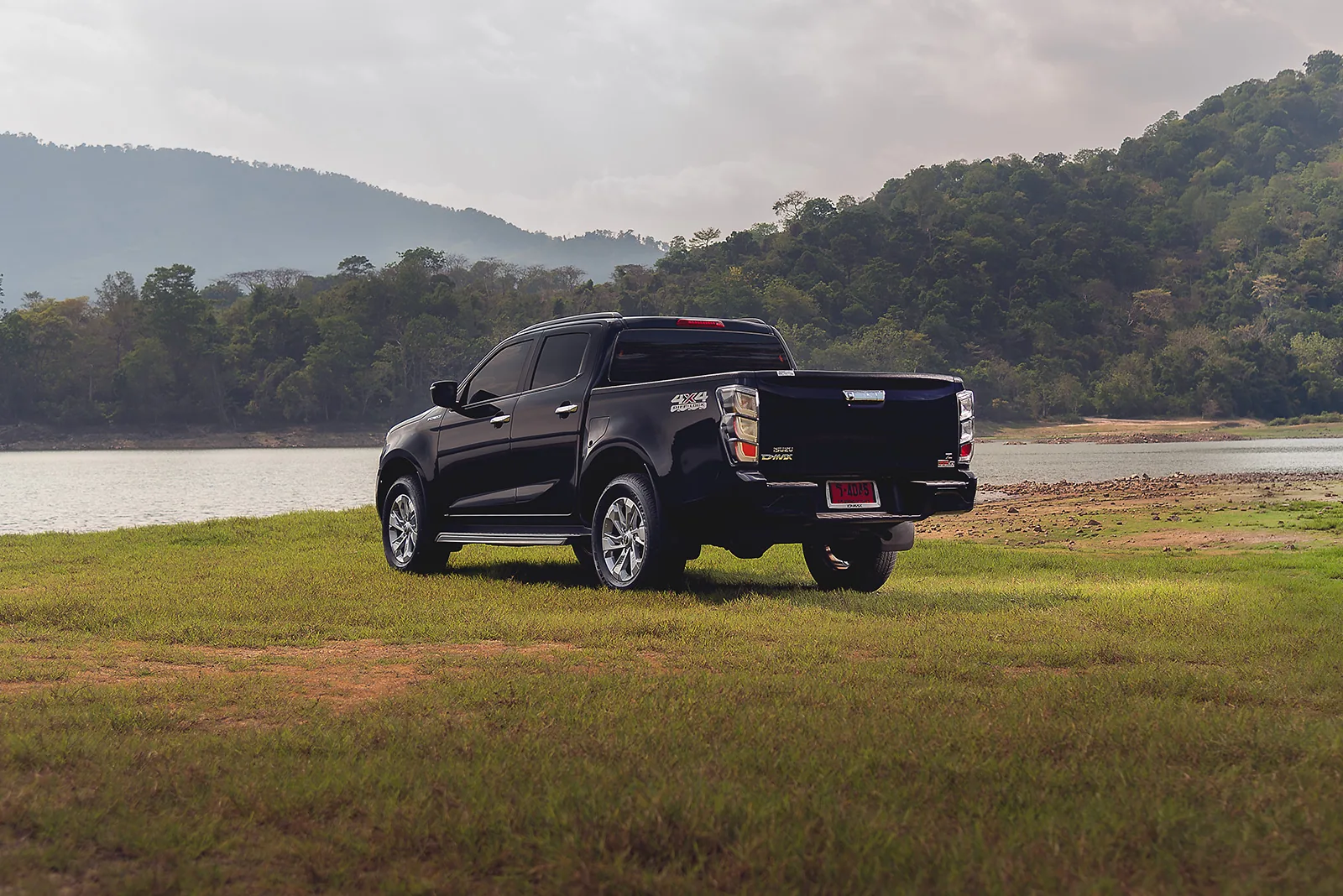 ภาพมุมกว้างท้ายเฉียงของ Isuzu V-Cross 2.2 เกรด Z จอดนิ่ง แสดงอุปกรณ์ตัวถังภายนอกที่มีรายละเอียดเหมือนกับรุ่นเครื่องยนต์ 3.0 ลิตร เกรด Z