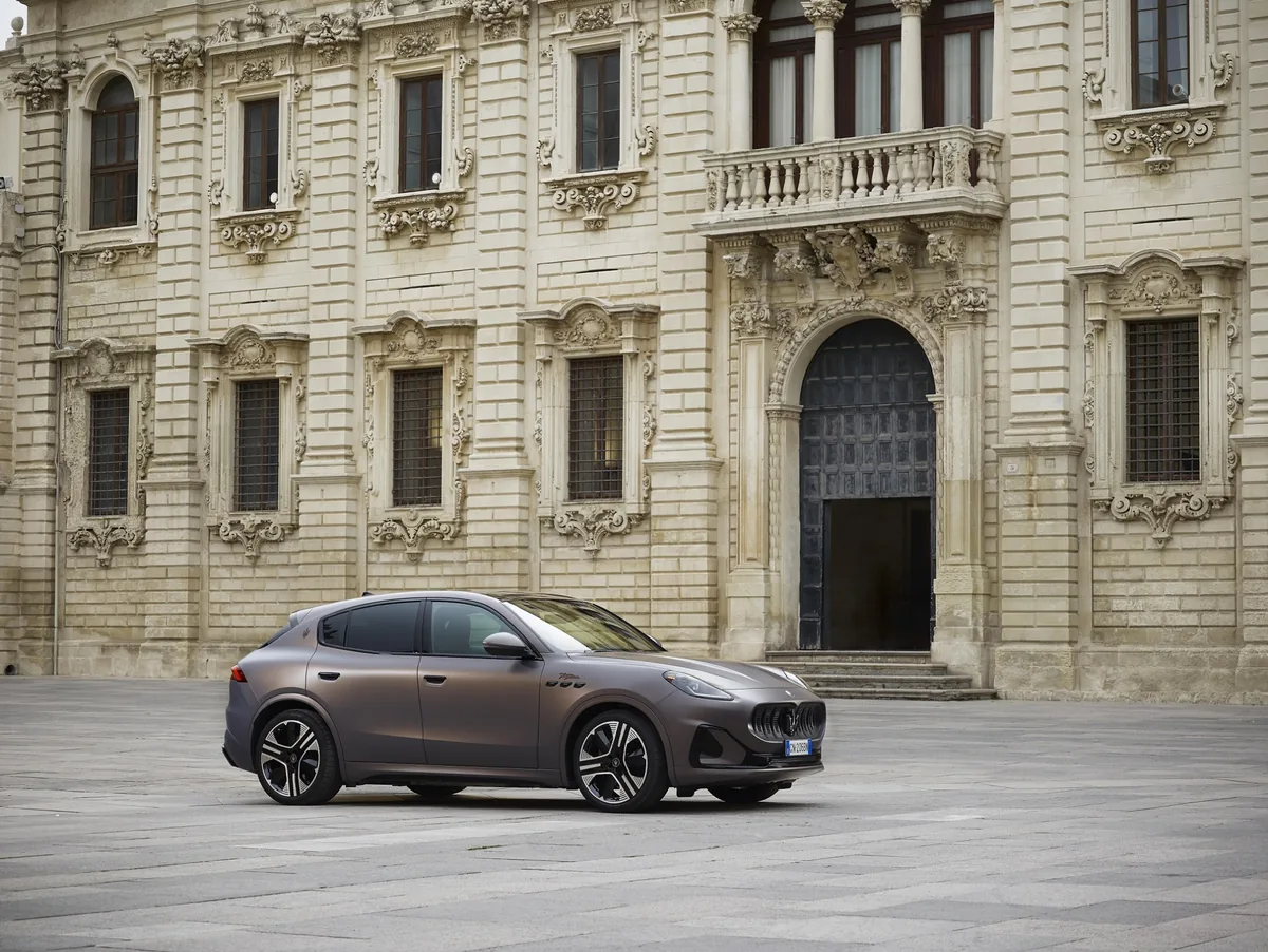 Maserati Grecale Folgore มุมด้านข้าง Maserati Grecale Folgore รถเอสยูวีไฟฟ้าสีบรอนซ์ด้าน มุมด้านข้าง จอดหน้าสถาปัตยกรรมคลาสสิก