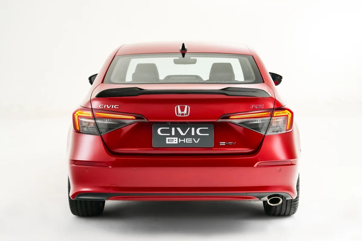 Honda Civic e:HEV RS สี Blazing Red Pearl มุมด้านหลัง Honda Civic e:HEV RS สีแดง Blazing Red Pearl มุมด้านหลัง พร้อมสปอยเลอร์และตราสัญลักษณ์ e:HEV