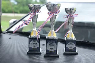 ถ้วยรางวัลการแข่งขัน TAJA X Revival Car Party วางบนฝากระโปรงรถ