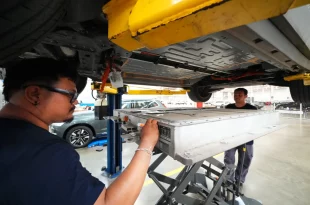 ช่างเทคนิคกำลังถอดแบตเตอรี่แรงดันสูงออกจากรถ Volvo EX30 ภายในศูนย์บริการ