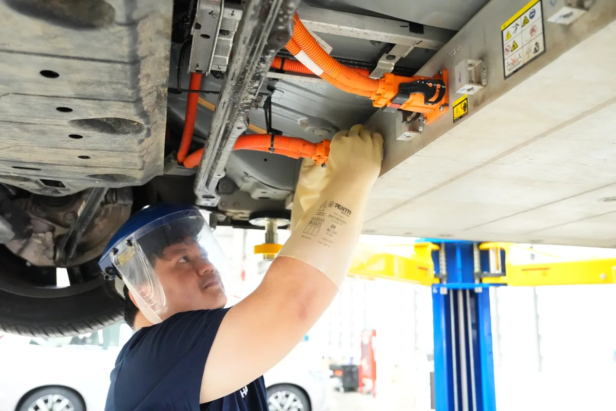 ขั้นตอนตรวจสอบระบบไฟฟ้าแรงดันสูง Volvo EX30 ช่างเทคนิคกำลังตรวจสอบและถอดขั้วต่อไฟฟ้าแรงดันสูงใต้ท้องรถ Volvo EX30