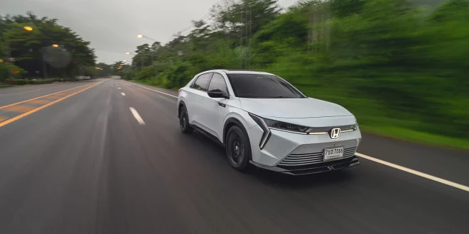 รถยนต์ไฟฟ้า Honda e:N2 เต็มคัน มุมหน้าเฉียง ขณะขับขี่ด้วยความเร็วในโหมด Sport ที่ให้อัตราเร่งทันใจขึ้น พร้อมระบบเสียงสังเคราะห์ทำงานร่วมกับการตัดเสียงภายนอกห้องโดยสาร