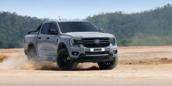 Ford Ranger Wolftrak สีเทาขณะขับบนพื้นดิน โดยมีฝุ่นฟุ้งจากล้อ มุมด้านหน้าเฉียง