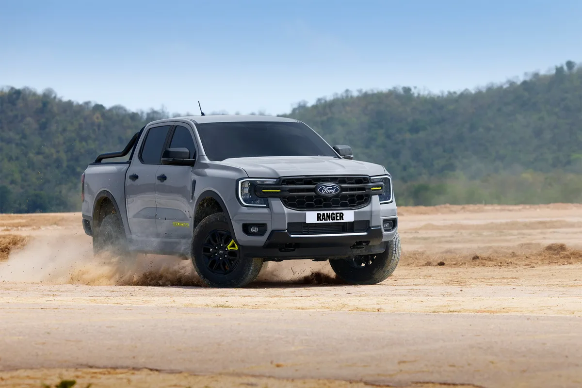 Ford Ranger Wolftrak Ford Ranger Wolftrak สีเทาขณะขับบนพื้นดิน โดยมีฝุ่นฟุ้งจากล้อ มุมด้านหน้าเฉียง