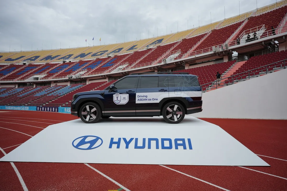 Hyundai Santa Fe Hybrid ด้านข้าง Hyundai Santa Fe Hybrid มุมมองด้านข้างพร้อมสติกเกอร์ Driving ASEAN as One ภายในสนามกีฬา