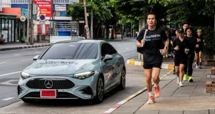 นักวิ่งวิ่งบนทางเท้าข้างรถ Mercedes-Benz ติดกราฟิก G/R/C ระหว่างกิจกรรม Mercedes-Benz x Garmin Run Club