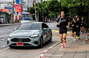 นักวิ่งวิ่งบนทางเท้าข้างรถ Mercedes-Benz ติดกราฟิก G/R/C ระหว่างกิจกรรม Mercedes-Benz x Garmin Run Club