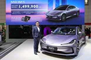 MG IM5 Exclusive Edition พร้อมบุคคลยืนข้างรถภายในบูธ และจอด้านหลังแสดงราคา 1,499,900 บาท