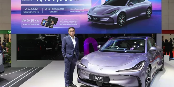 MG IM5 Exclusive Edition พร้อมบุคคลยืนข้างรถภายในบูธ และจอด้านหลังแสดงราคา 1,499,900 บาท