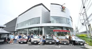 กลุ่มผู้ร่วมกิจกรรม CLUB & COFFEE ถ่ายภาพหน้าศูนย์ Porsche Centre Bangkok พร้อมรถจอดเรียงด้านหน้า