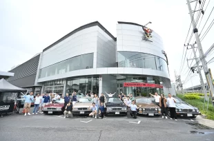 กลุ่มผู้ร่วมกิจกรรม CLUB & COFFEE ถ่ายภาพหน้าศูนย์ Porsche Centre Bangkok พร้อมรถจอดเรียงด้านหน้า
