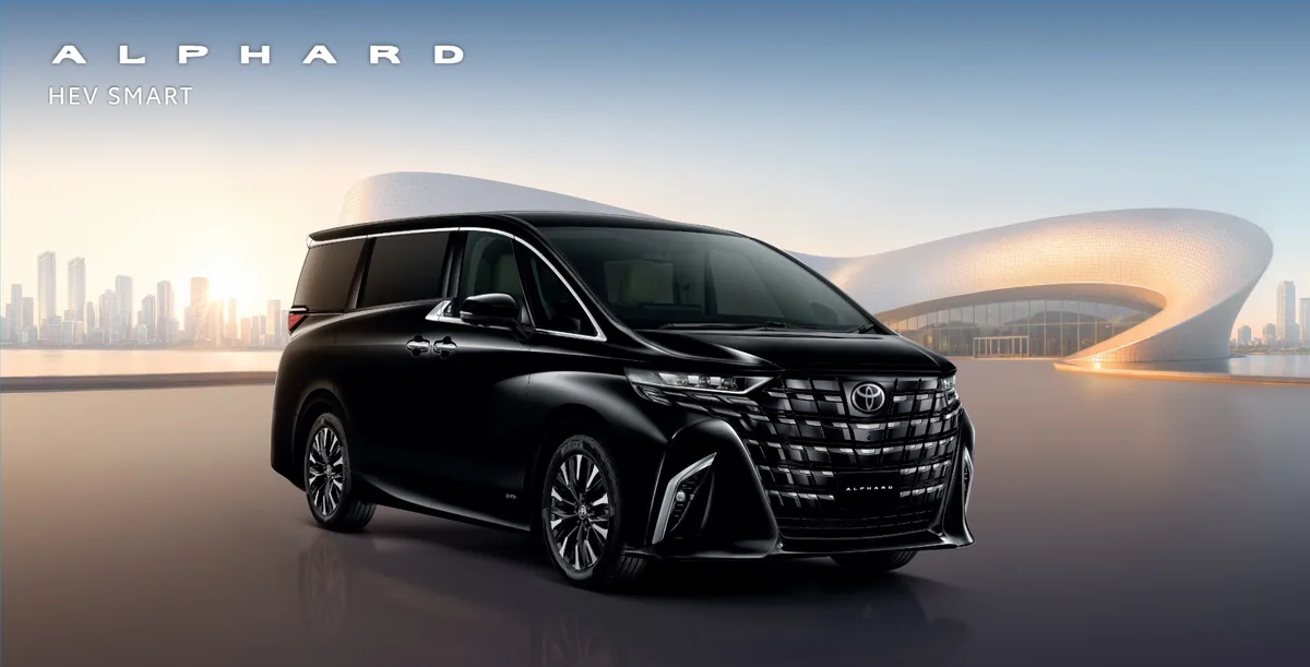 Toyota Alphard HEV Smart Toyota Alphard HEV Smart สีดำ มุมด้านหน้าเฉียง พร้อมฉากหลังสถาปัตยกรรมสมัยใหม่