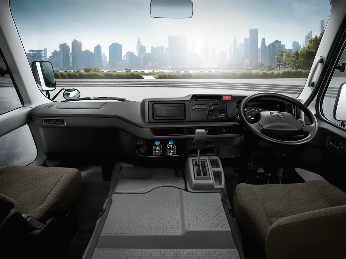 ห้องคนขับ Toyota Coaster ใหม่ ห้องคนขับ Toyota Coaster ใหม่ พร้อมพวงมาลัย แผงควบคุม และคันเกียร์อัตโนมัติ