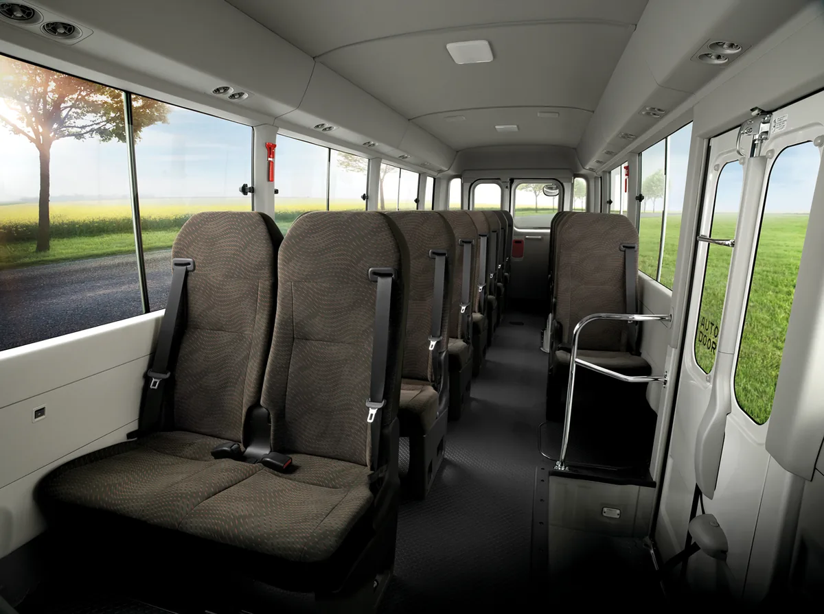 ห้องโดยสาร Toyota Coaster ใหม่ ห้องโดยสาร Toyota Coaster ใหม่ แสดงเบาะผู้โดยสาร ทางเดิน และพื้นที่ภายในรถ