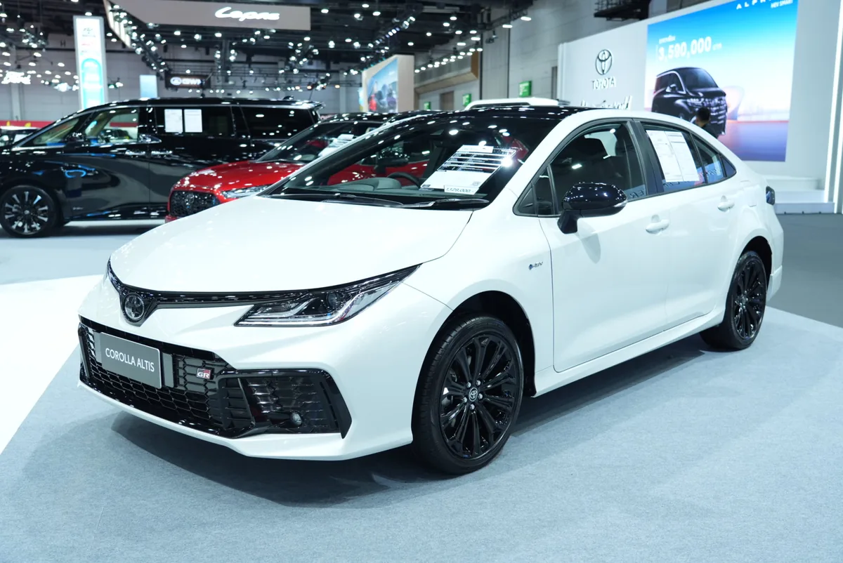 Toyota Corolla Altis พร้อมสัญลักษณ์ GR สีขาว Toyota Corolla Altis สีขาว พร้อมสัญลักษณ์ GR มุมด้านหน้าเฉียง ภายในบูท Toyota ในงาน BIG MOTOR SALE 2026