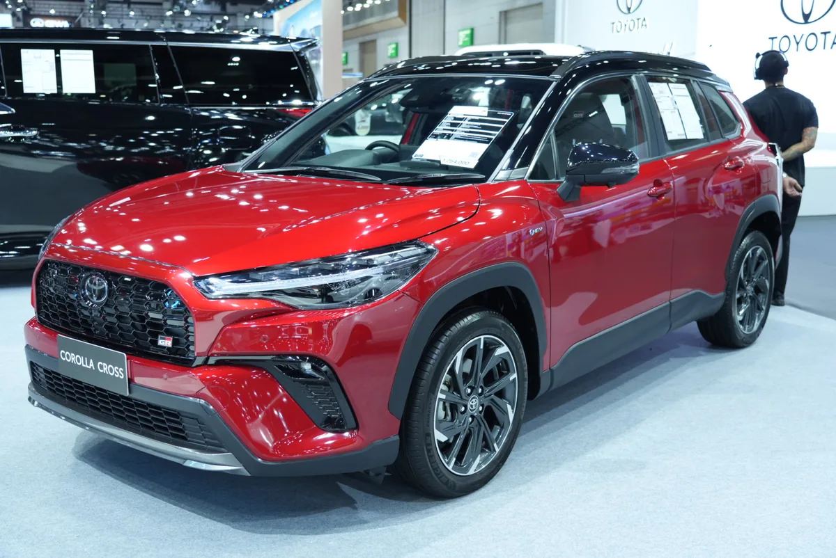 Toyota Corolla Cross พร้อมสัญลักษณ์ GR สีแดง Toyota Corolla Cross สีแดง พร้อมสัญลักษณ์ GR มุมด้านหน้าเฉียง ภายในบูท Toyota ในงาน BIG MOTOR SALE 2026
