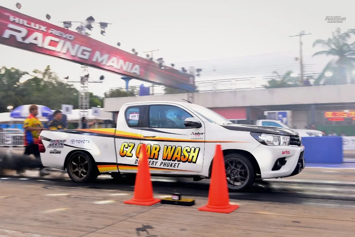 กระบะ Toyota สีขาวในสนามแข่ง รถแข่งกระบะ Toyota สีขาววิ่งผ่านบริเวณสตาร์ตในงาน Hilux Revo Racing Mania 2026