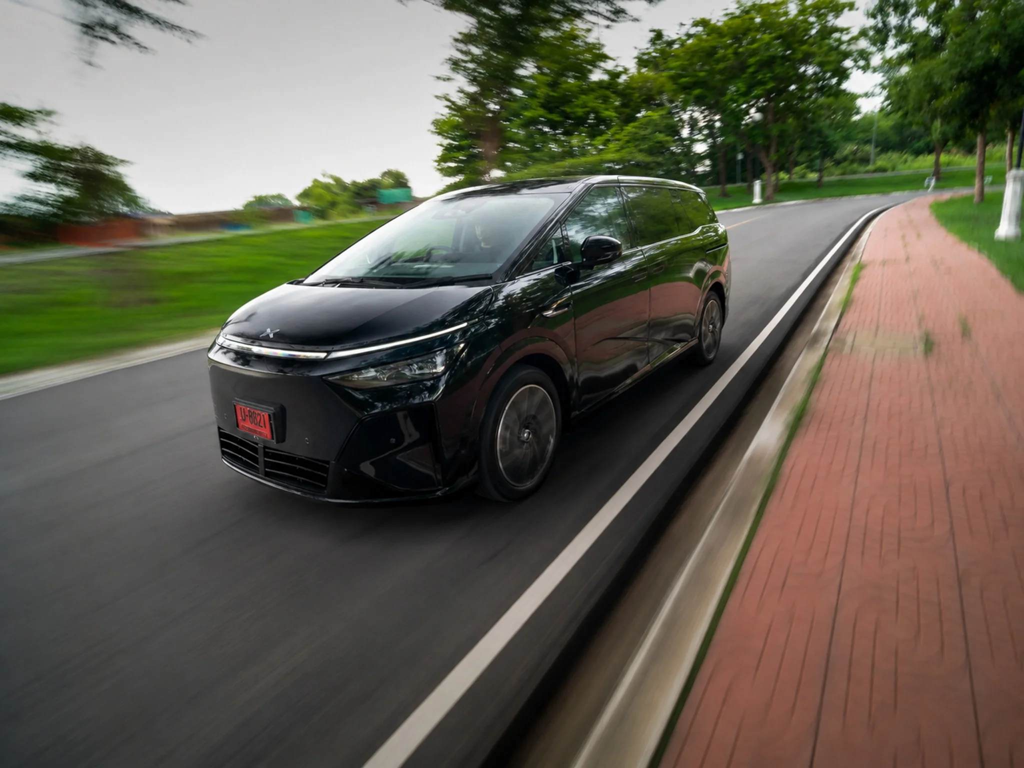 XPeng X9 ตัวถังสีดำ ขณะขับขี่ทดสอบบนถนนจริง สะท้อนอัตราเร่งและแรงบิดพร้อมการอัปเดตค่า C-Rate จาก 3C เป็น 5C ที่ช่วยให้มอเตอร์ไฟฟ้าดึงพลังงานไปใช้เร่งแซงได้ต่อเนื่อง
