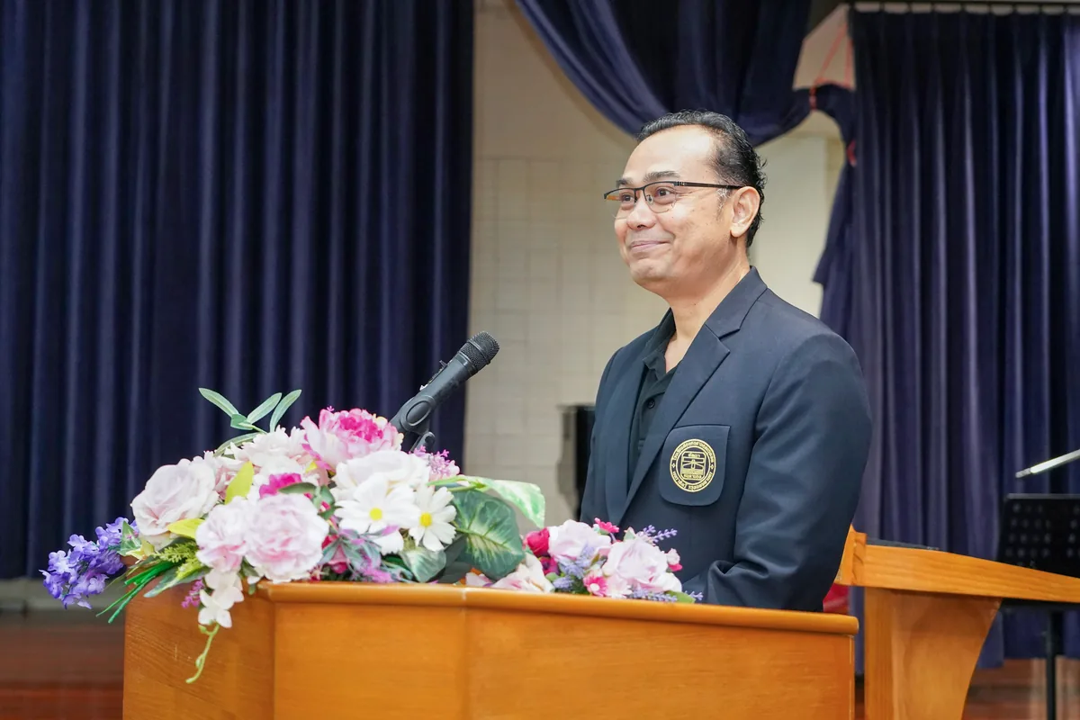 พิริยภณ ธนาพัฒน์ธำรง ผู้ช่วยผู้อำนวยการฝ่ายปฏิบัติการ โรงเรียนสอนคนตาบอดกรุงเทพ พิริยภณ ธนาพัฒน์ธำรง กล่าวบนเวทีหลังแท่นบรรยายที่ประดับดอกไม้