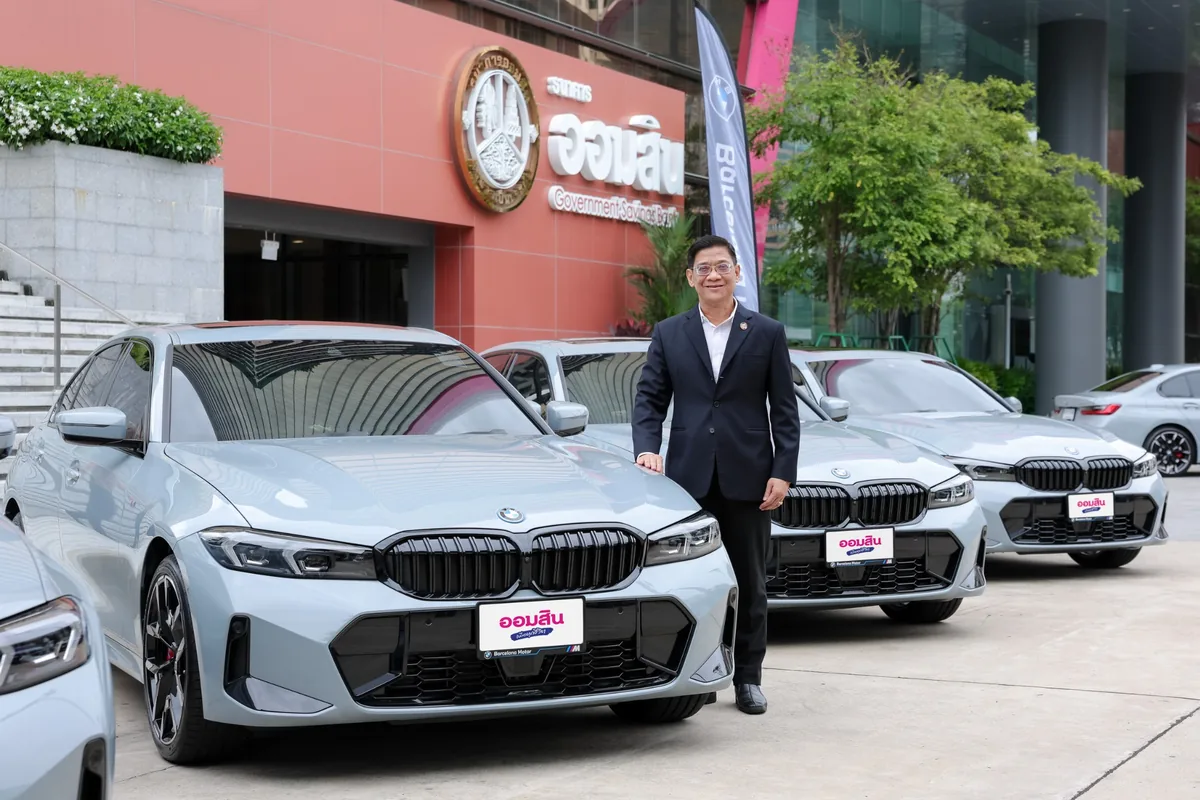 นายภิรมย์ โพธิ์เจริญ จากธนาคารออมสิน ผู้แทนธนาคารออมสินยืนคู่กับ BMW 330e M Sport ด้านหน้าอาคารธนาคารออมสิน