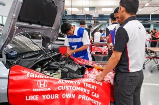 ผู้เข้าแข่งขัน Honda Skill Contest 2026 ปฏิบัติงานบริเวณห้องเครื่องรถ โดยมีผู้ดูแลกิจกรรมอยู่ใกล้เคียง
