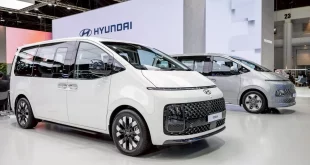 Hyundai STARIA สีขาว จัดแสดงในมุมด้านหน้าสามส่วนภายในพื้นที่แสดงรถฮุนได