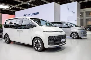 Hyundai STARIA สีขาว จัดแสดงในมุมด้านหน้าสามส่วนภายในพื้นที่แสดงรถฮุนได
