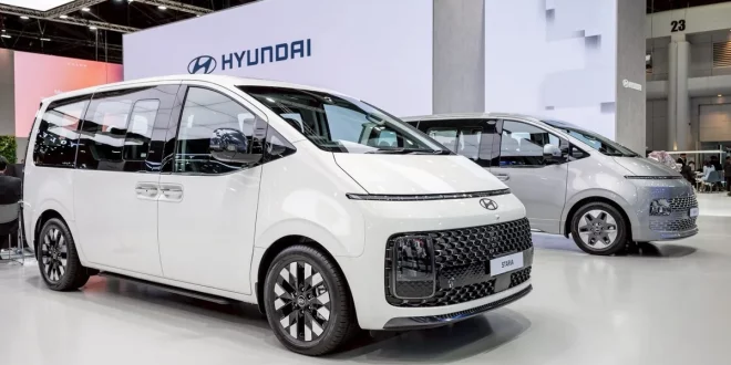 Hyundai STARIA สีขาว จัดแสดงในมุมด้านหน้าสามส่วนภายในพื้นที่แสดงรถฮุนได