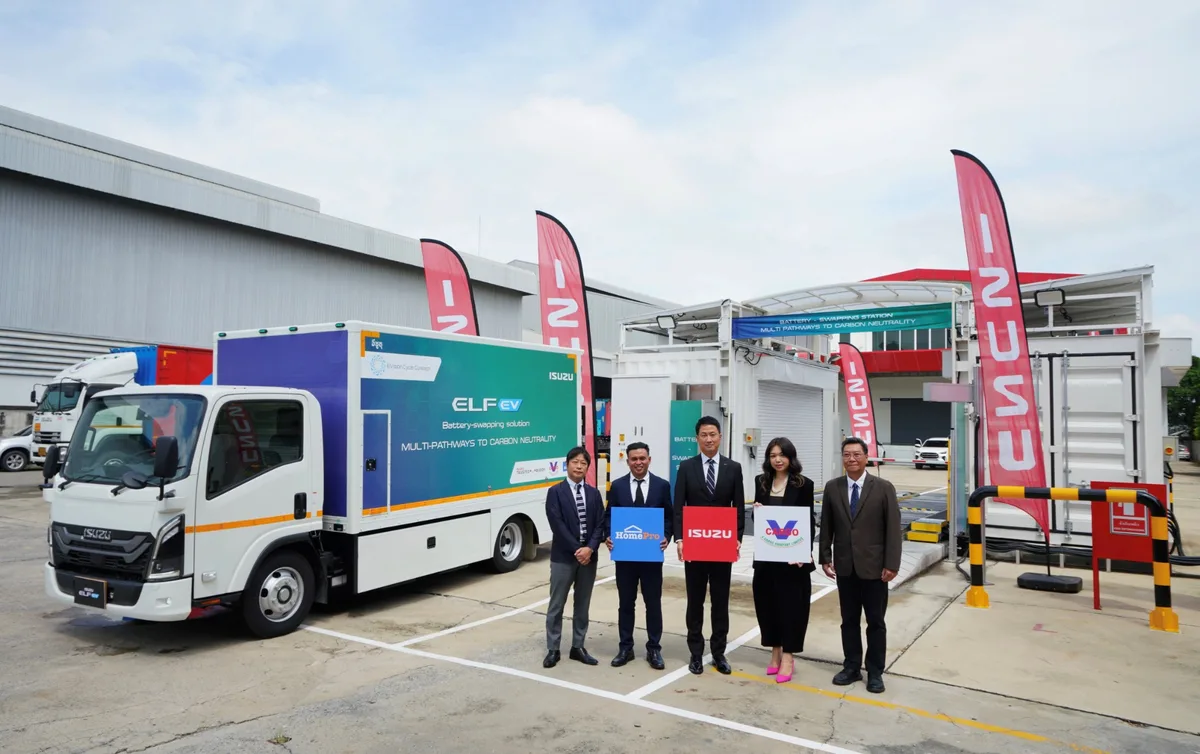 Isuzu ELF EV กับผู้ร่วมโครงการ Battery Swapping Isuzu ELF EV จอดข้างสถานีสับเปลี่ยนแบตเตอรี่ พร้อมผู้ร่วมโครงการถ่ายภาพร่วมกัน