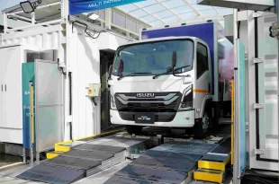 Isuzu ELF EV มุมด้านหน้า ขณะอยู่ภายในสถานีสับเปลี่ยนแบตเตอรี่