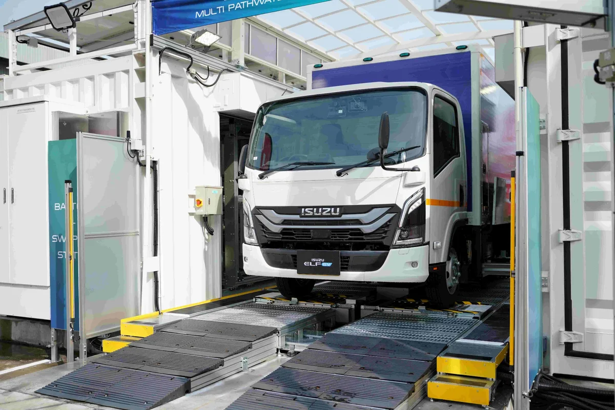 Isuzu ELF EV ในสถานีสับเปลี่ยนแบตเตอรี่ Isuzu ELF EV มุมด้านหน้า ขณะอยู่ภายในสถานีสับเปลี่ยนแบตเตอรี่