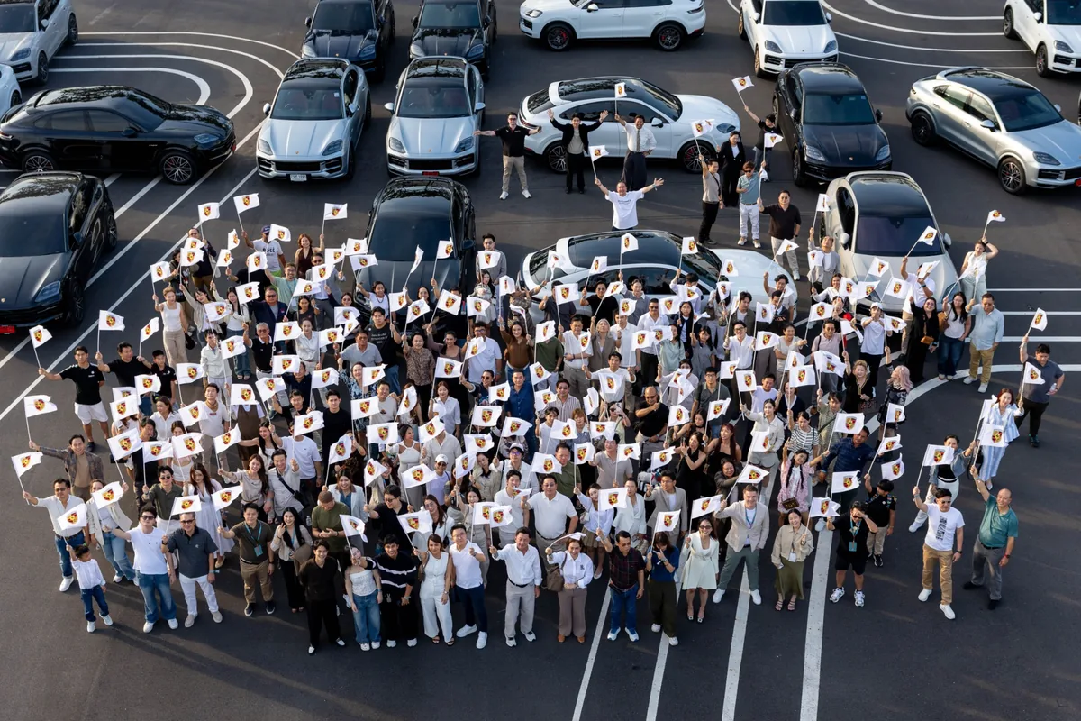 คอมมูนิตี้ Porsche Cayenne ในงาน Haus of Porsche ผู้เข้าร่วมงาน Haus of Porsche: Cayenne Edition ถ่ายภาพร่วมกันท่ามกลางรถ Porsche Cayenne หลายคัน