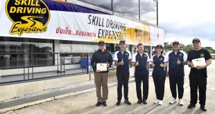 ผู้เข้าร่วมกิจกรรมยืนถ่ายภาพร่วมกันหน้าป้าย Skill Driving Experience