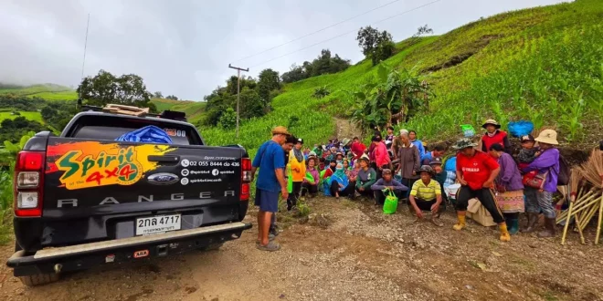รถกระบะ Ford Ranger ของ SPIRIT 4x4 จอดข้างกลุ่มชาวบ้านระหว่างกิจกรรมช่วยเหลือผู้ได้รับผลกระทบจากน้ำท่วม