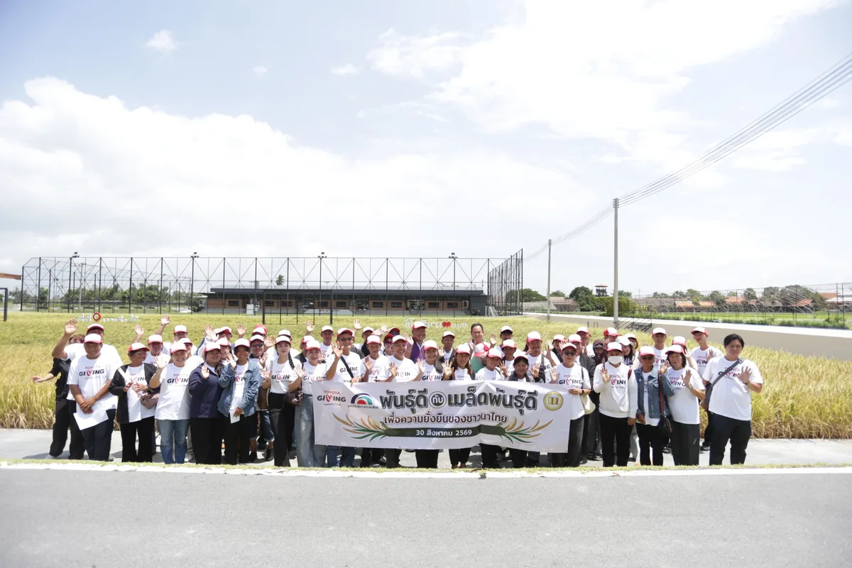 ภาพหมู่ในแปลงนาสาธิต ผู้เข้าร่วมโครงการ TTF FROM BOOK TO FIELD ถ่ายภาพหมู่กลางแปลงนาสาธิตพร้อมป้ายกิจกรรม