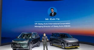เออร์วิน เย่ ยืนบนเวทีพร้อมรถ Geely สองคันและข้อมูลบนฉากหลัง