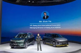 เออร์วิน เย่ ยืนบนเวทีพร้อมรถ Geely สองคันและข้อมูลบนฉากหลัง