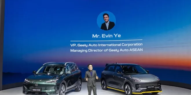 เออร์วิน เย่ ยืนบนเวทีพร้อมรถ Geely สองคันและข้อมูลบนฉากหลัง