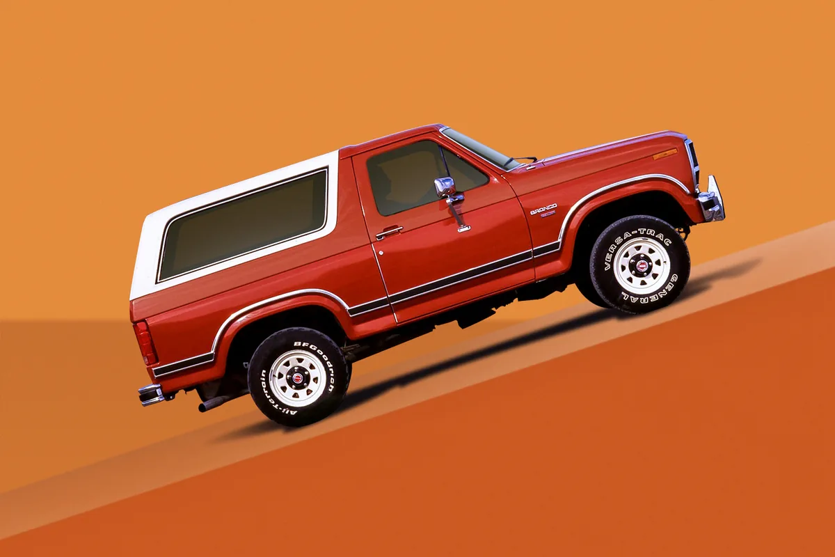 Ford Bronco เจเนอเรชันที่ 3 สีแดง มุมด้านข้างบนพื้นหลังสีส้ม Ford Bronco เจเนอเรชันที่ 3 สีแดง มุมด้านข้างบนพื้นหลังสีส้ม