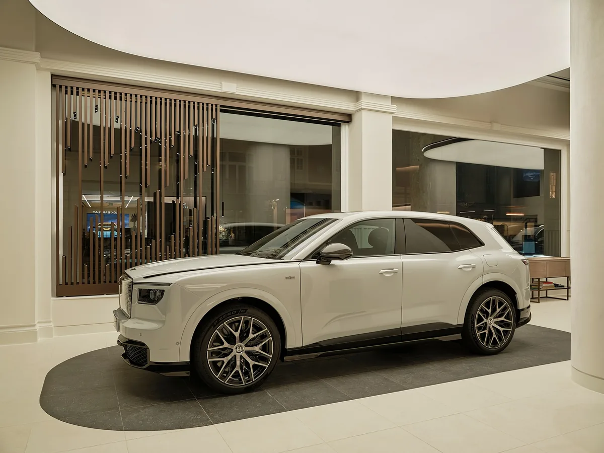 รถ Bentley สีขาวภายในโชว์รูม รถยนต์ Bentley สีขาวมุมด้านข้างจัดแสดงอยู่ภายในโชว์รูมที่ตกแต่งด้วยโทนสีอ่อน