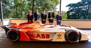 รถแข่ง Formula E GEN 4 สีส้มและขาว ติดโลโก้ Bridgestone บนตัวรถและยาง พร้อมผู้แทนองค์กร 5 คนยืนด้านหลังในงาน Bridgestone Formula E World Premiere
