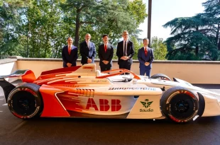 รถแข่ง Formula E GEN 4 สีส้มและขาว ติดโลโก้ Bridgestone บนตัวรถและยาง พร้อมผู้แทนองค์กร 5 คนยืนด้านหลังในงาน Bridgestone Formula E World Premiere