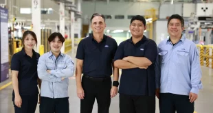 บุคลากรฟอร์ด 5 คนยืนถ่ายภาพร่วมกันภายในโรงงานผลิตรถยนต์