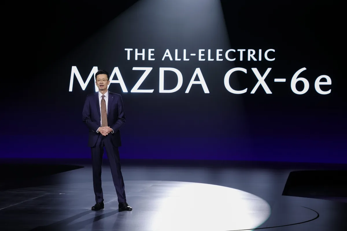 โทรุ นากาจิม่า Senior Executive Officer ของ Mazda Motor Corporation ผู้บรรยายบนเวทีเปิดตัว พร้อมข้อความ The All-Electric Mazda CX-6e บนฉากหลัง